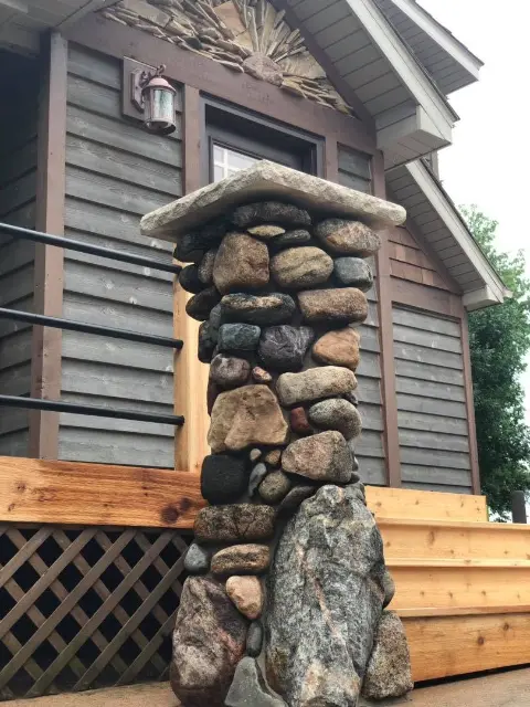 Unique stone pillar with flat top near wooden deck entrance